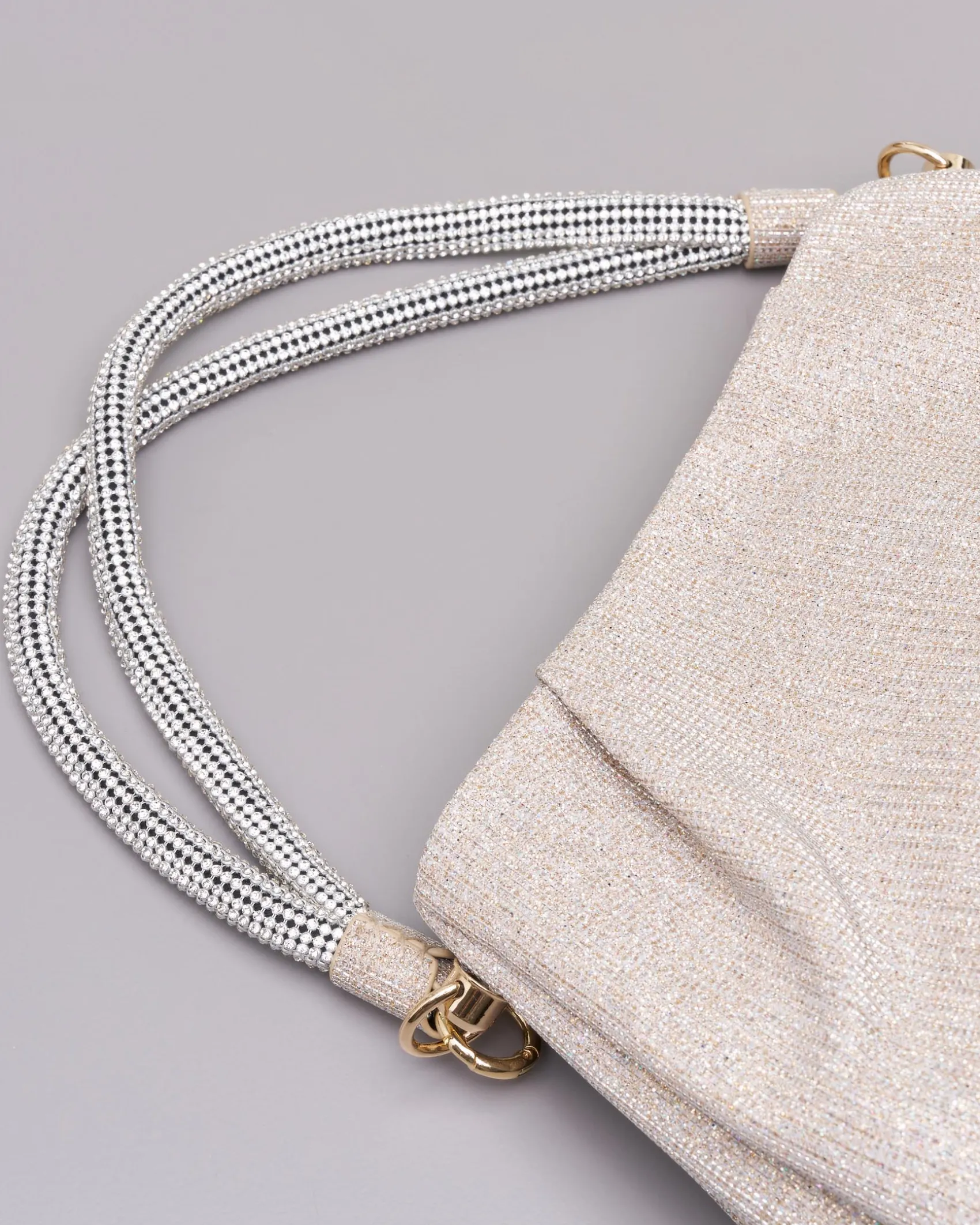 Borsa color platino in tessuto glitter con manico rivestito in strass argento