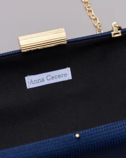 Clutch rigida blu in tessuto lavorato a micro rete con chiusura a scatto tubolare in metallo dorato