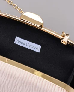 Clutch rigida color champagne in tessuto goffrato con profili e chiusura scatto in metallo dorato