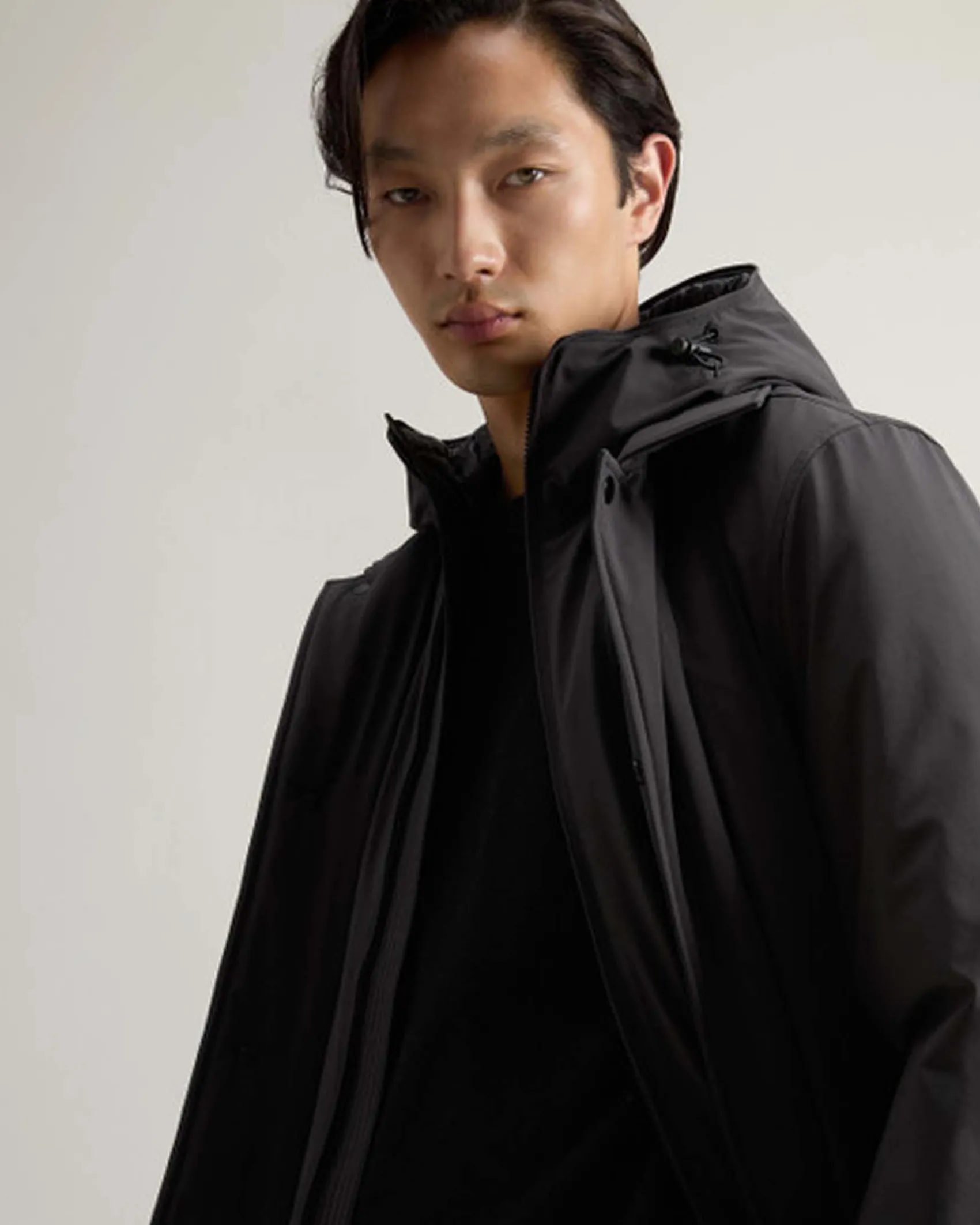 Impermeabile nero Woolrich in tessuto stretch con davantino e cappuccio staccabili