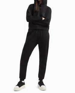 Joggers slim-fit neri in tessuto scuba con logo al fondo in strass applicati