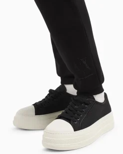 Joggers slim-fit neri in tessuto scuba con logo al fondo in strass applicati