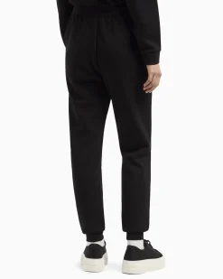 Joggers slim-fit neri in tessuto scuba con logo al fondo in strass applicati
