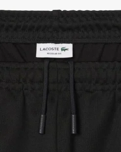 Pantaloni Lacoste neri in felpa piqué interlock di cotone con piping in contrasto