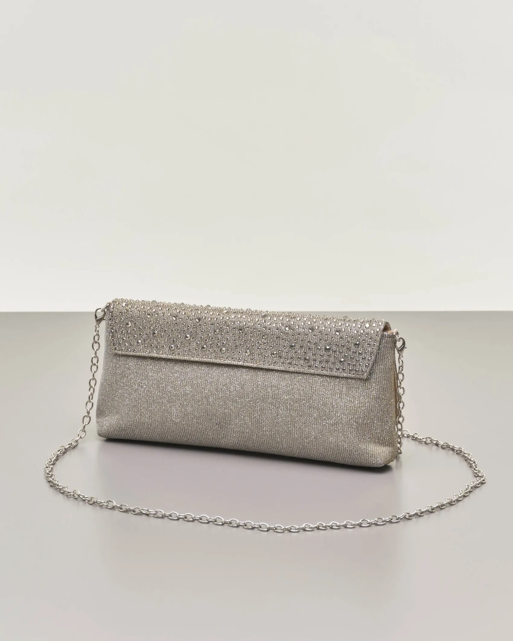 Pochette a busta color peltro in lurex con strass tono su tono applicati sulla patta di chiusura