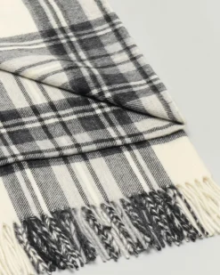 Sciarpa in lana merino color avorio a fantasia tartan nera con frange al fondo